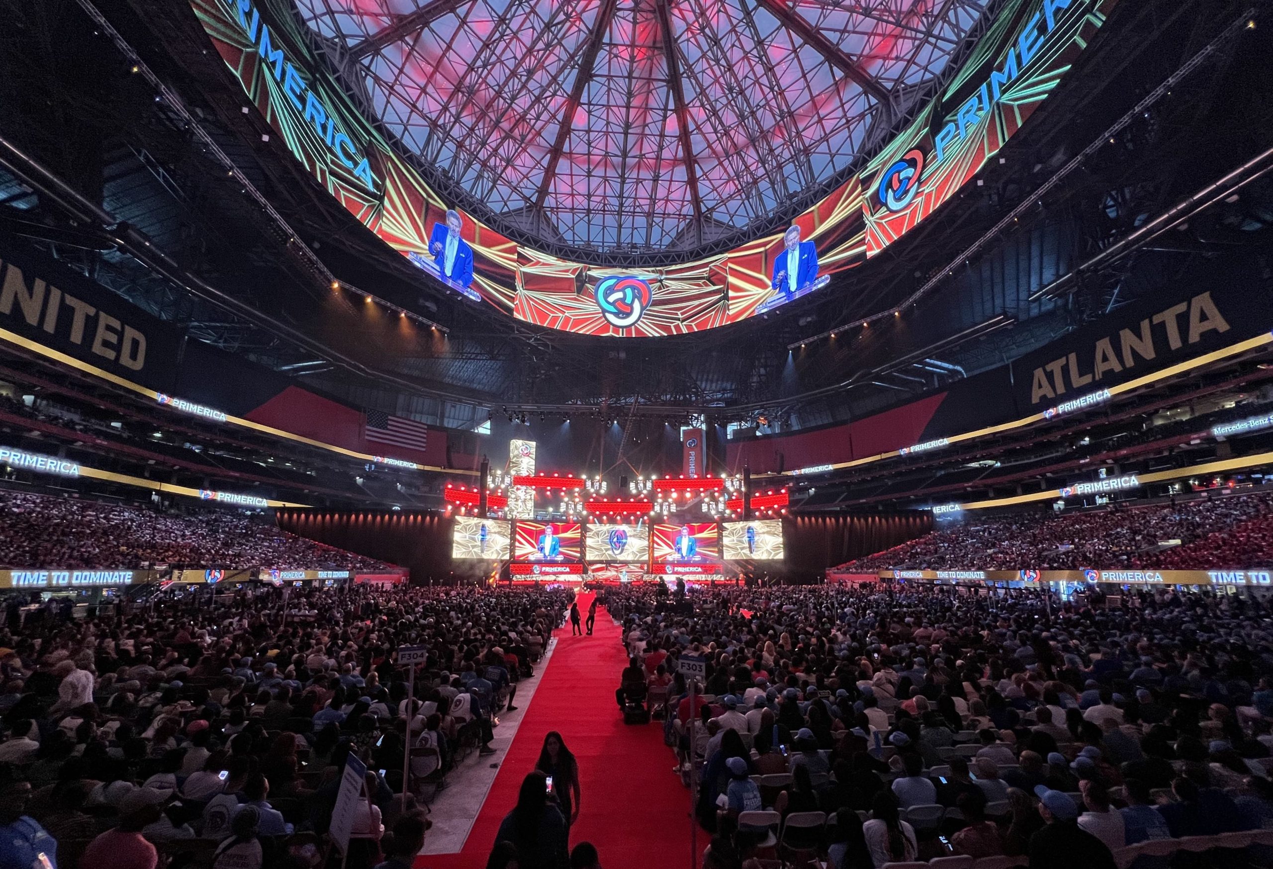 The stage at the Mercedes-Benz stadium during the Primerica International Convention with the word “Primerica” shown across multiple TV screens.