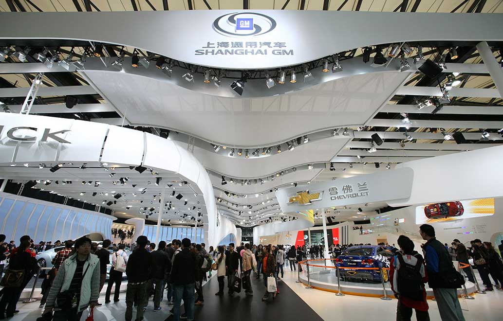 People visit the stand of Shanghai GM